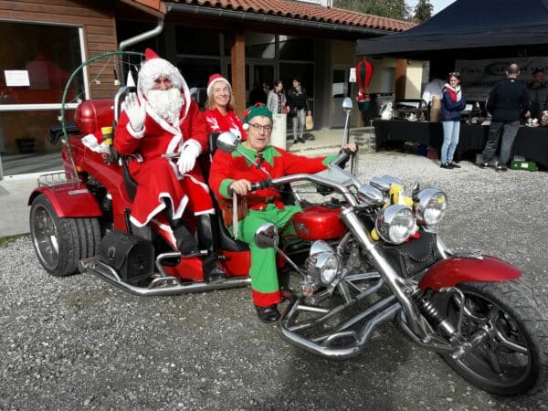 Le Père Noël et ses lutins se modernisent ! Au rencart le traîneau, voici venu le trike rouge tout rutilant pour faire la tournée des cadeaux et promener les enfants et les parents au marché de Saint Marcet.